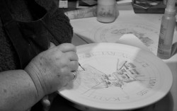 Julia Catt Hand painting and lettering a Rye Pottery Plate